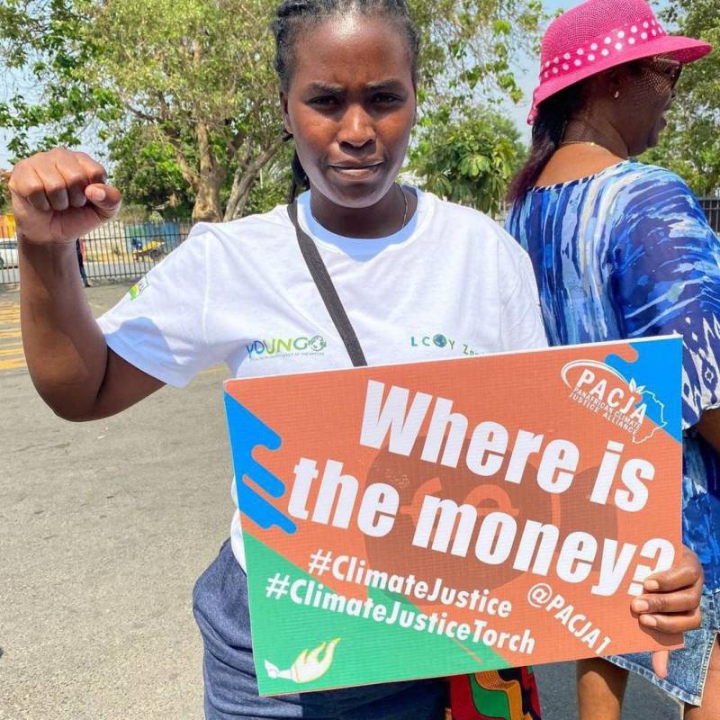 Precious Kalombwana, Zambian activist holding a protest sign