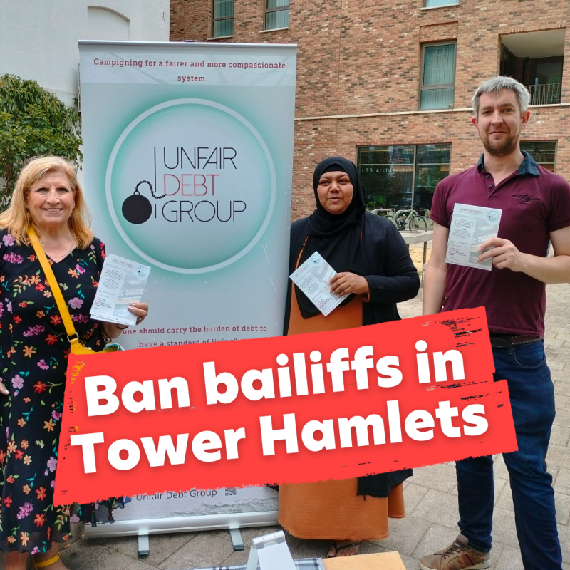 Image description: Unfair Debt Group members standing by their regular stall with leaflets. Text reads: ban bailiffs in Tower Hamlets